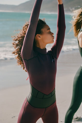 Model wearing the Longsleeve springsuit wetsuit in Mulberry together with the mulberry waterleggings. 